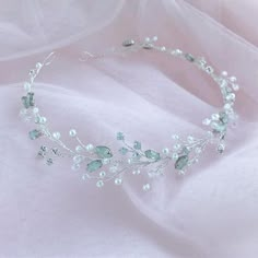 a tiara with green and white flowers on it