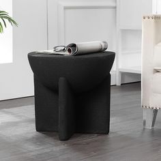 a black table sitting on top of a hard wood floor next to a white chair