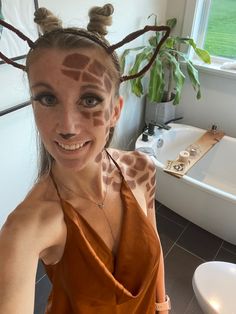 a woman with giraffe print on her face posing for a photo in the bathroom