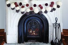 a fireplace decorated with pom poms and flowers