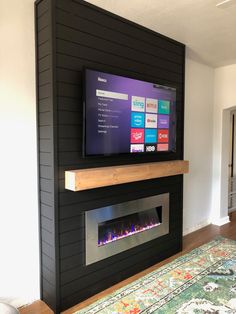 a flat screen tv mounted to the side of a wall next to a fire place