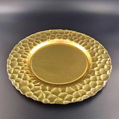 an empty gold plate on a black surface