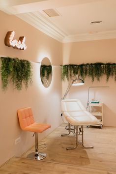 a chair and mirror in a room with plants on the wall