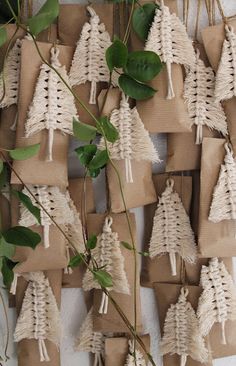 small christmas trees are wrapped in brown paper and tied to twine with greenery