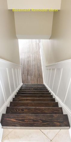 the stairs are made of wood and have white painted trim on each side, along with black handrails that lead up to the second floor