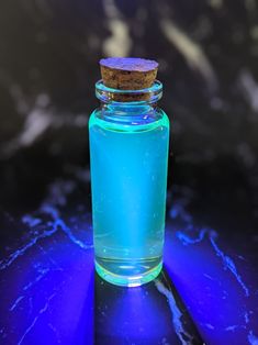 a blue glass bottle with a cork lid