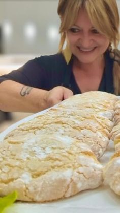 a woman sitting at a table with some bread on it