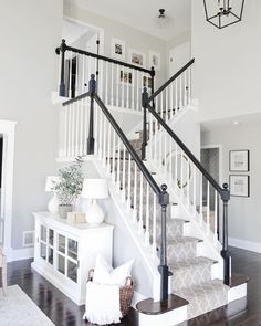 a white staircase with black railings and wood flooring