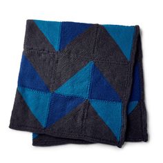 a blue and black blanket on top of a white surface with an image of a triangle in the middle