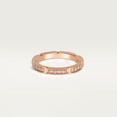 a rose gold ring with small diamonds on the inside and outside, set against a white background