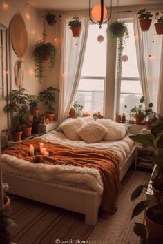 a bedroom with potted plants and candles in the window sill, along with an unmade bed