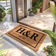 a door mat that says her and is on the outside of a house with potted plants