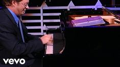 a man in a suit and tie playing a piano