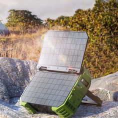 a solar powered device sitting on top of a rock