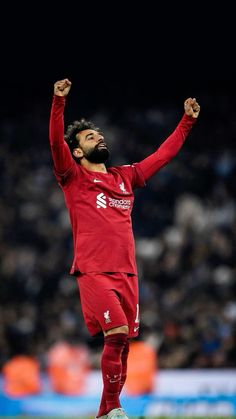 a soccer player with his arms in the air