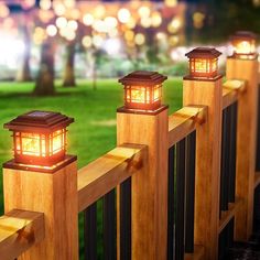 three wooden posts with lights on them in the grass