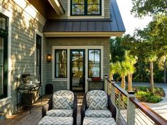 two chairs sitting on the front porch of a house