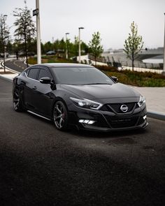 a black car is parked on the side of the road