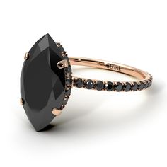 a black diamond engagement ring with rose gold accents and an oval cut stone in the center