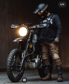 a man is standing next to his motorcycle with the light on it's head