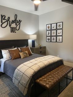 a bed room with a neatly made bed and pictures on the wall above it's headboard