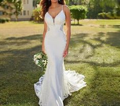 a woman in a wedding dress standing on the grass