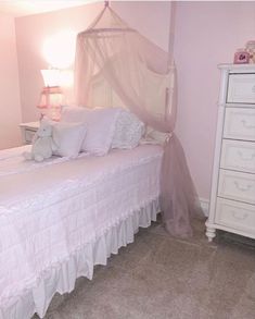 a white bed sitting in a bedroom next to a night stand and chest of drawers