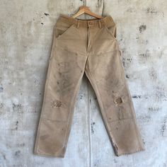 "Vintage Tan Double Knee Carhartt Pants Relaxed fit Well worn Size measured flat: 30x30 Model: 5\"10\" - Waist: 15\" (across top waistband) - Inseam: 30\" (crotch seam to bottom hem) - Rise: 12\" (crotch seam to top of waist) - Hips: 21\" (straight across below end of zipper) - Thigh: 12\" (crotch seam to outseam) - Knee: 10\" - Cuff: 9\" (lower leg opening)" Rugged Straight Leg Pre-washed Bottoms, Rugged Straight Leg Bottoms, Pre-washed, Vintage Distressed Cotton Pants, Rugged Cotton Bottoms With Standard Cut Leg, Double Knee Carhartt, Pantalon Carhartt, Carhartt Pants, Hunting Jackets, Lower Leg