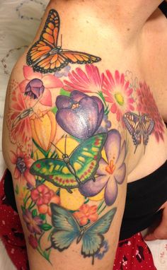 a woman's breast with butterflies and flowers on it