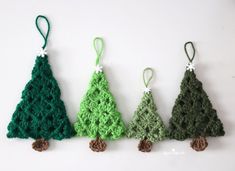 three crocheted christmas trees are hanging on the wall, one green and one brown