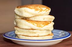 a stack of pancakes sitting on top of a blue and white plate