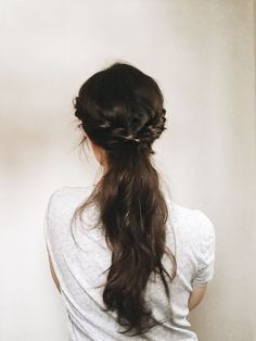 a woman with long hair standing in front of a wall