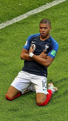 a soccer player sitting on the ground with his arms crossed