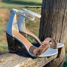 a pair of shoes sitting on top of a wooden fence