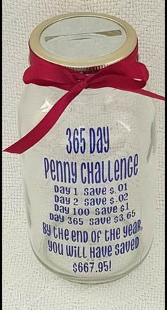 a glass jar with a red ribbon tied around the top and writing on it that says 365 day penny challenge