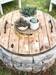 two potted plants sitting on top of a wooden table next to a white chair