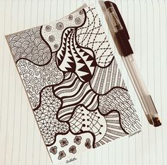 a pen is laying on top of a piece of paper that has an intricate design