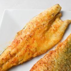 two pieces of fried fish on a white plate