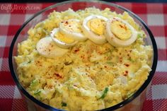 a bowl filled with eggs on top of a red and white checkered table cloth