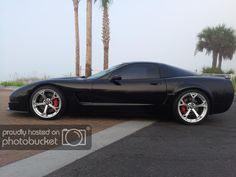 a black sports car parked in front of palm trees