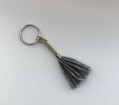 a metal keychain with a tassel on it