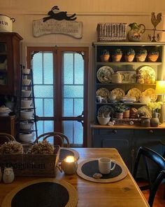 a wooden table topped with plates and cups