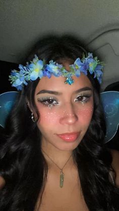 a woman with blue flowers in her hair wearing a flower headband and butterfly wings