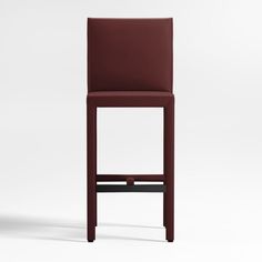 a red leather bar stool sitting on top of a white floor next to a wall