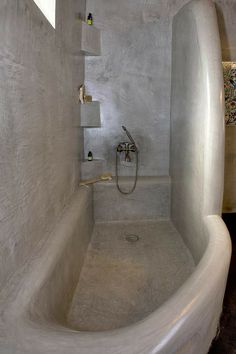 a white bath tub sitting inside of a bathroom next to a shower head and faucet