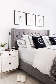 a bed with white sheets and pillows in a bedroom next to two framed pictures on the wall