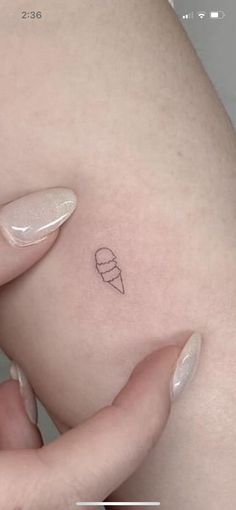 a small tattoo on the side of a woman's stomach shows an ice cream cone