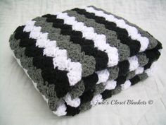 three black and white crocheted blankets stacked on top of each other in the shape of squares