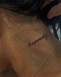 the back of a woman's neck with her name tattoo