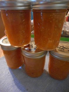 four jars filled with honey sitting on top of a table